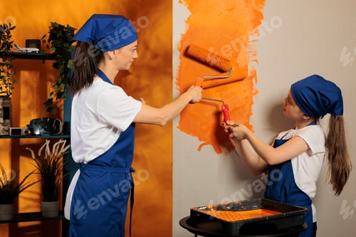 Preview: Small girl helping mom painting walls