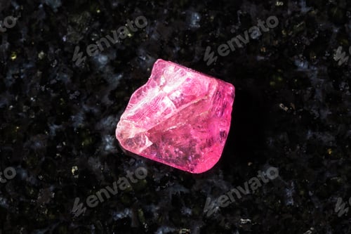 Preview: rough pink spinel crystal on black granite