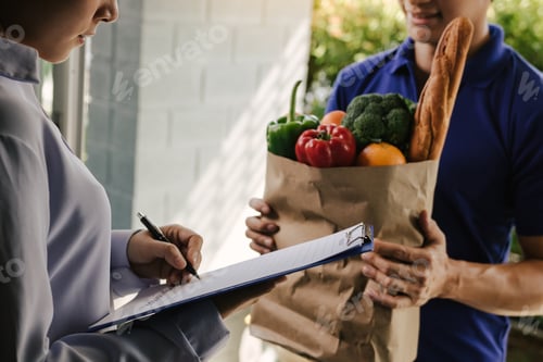 Preview: Asian woman is checking the product and signing the receipt on the order