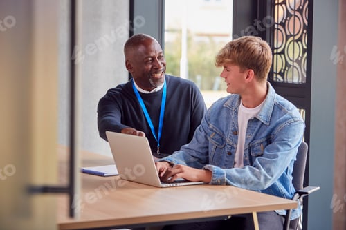 Preview: Male University Or College Student With Laptop Having Individual Meeting With Tutor