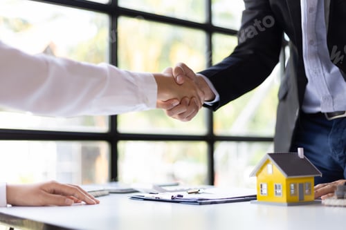 Preview: Businessman shaking hands with real estate agent in office after reaching home purchase agreement.