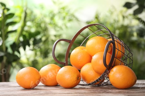 Preview: Basket and fresh oranges on wooden table. Space for text