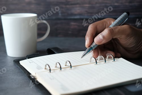 Preview: close up of person hand writing on notepad.