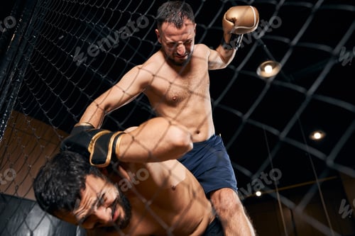 Preview: Muscular man covering his head under punches