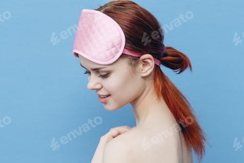 Preview: happy woman with sleep mask on her head blue background Copy Space