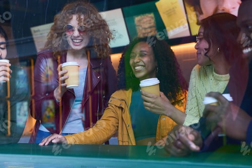 Preview: Cheerful multi ethnic friends enjoying coffee break together