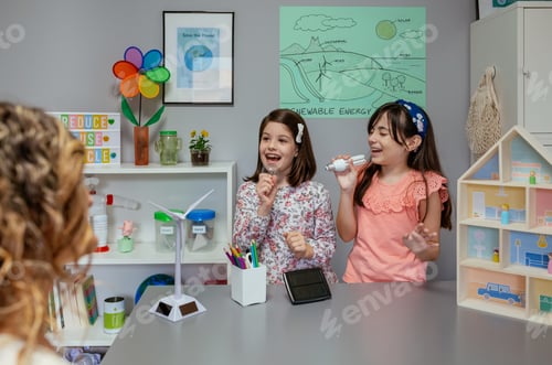 Preview: Female students singing using light bulbs as microphones in ecology classroom