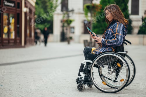 Preview: Woman with disability using a smartphone while out in the city