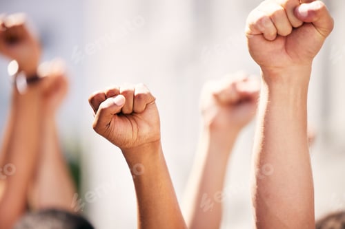 Preview: Fighting the dominant power. Shot of a group of people with their fists raised at a protest.