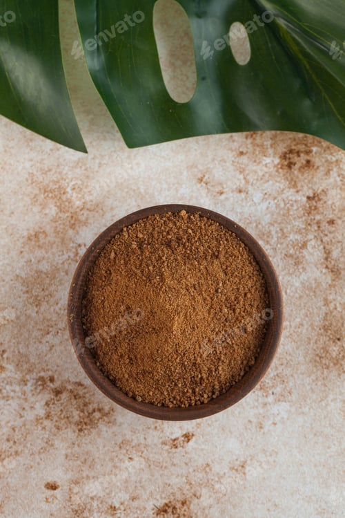Preview: Coconut sugar in a wooden bowl with a palm leaf. Minimalism. The concept of healthy eating.