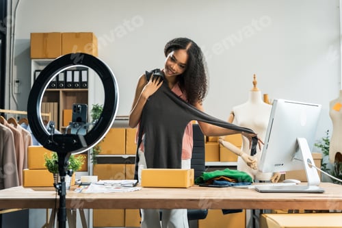 Preview: African American woman with an afro at a desk in a clothing store, managing logistics and orders.