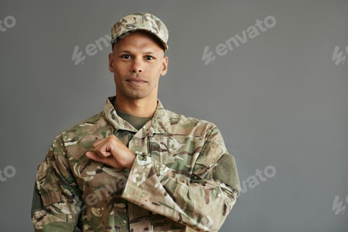 Preview: Man in Camouflage Uniform Against a Gray Background