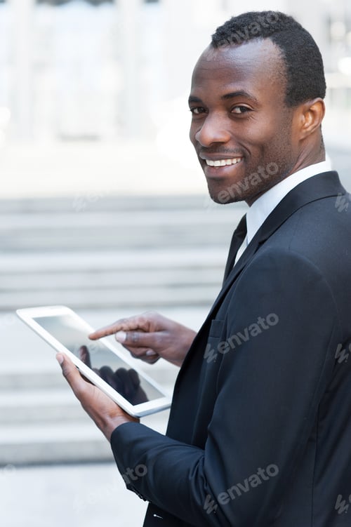 Man Working Confidently on a Tablet in Urban Setting