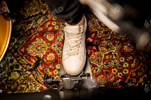 Preview: Foot of young musician wearing cross-shoes pushing pedal of electric drumset