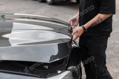 Preview: Man opens the hood of the car and looks for faults. The professional guy starts the job, the concept