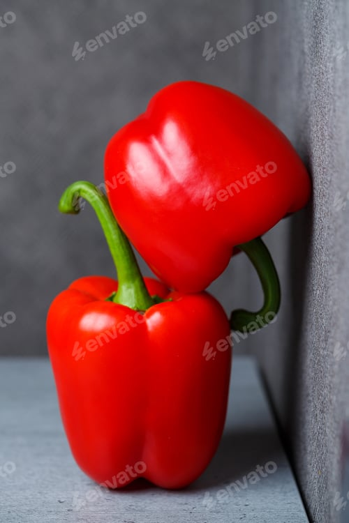 Preview: Two red peppers on a grey table