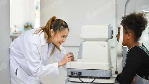 Preview: Teenage woman checking eyesight on auto refractor in ophthalmologist clinic.