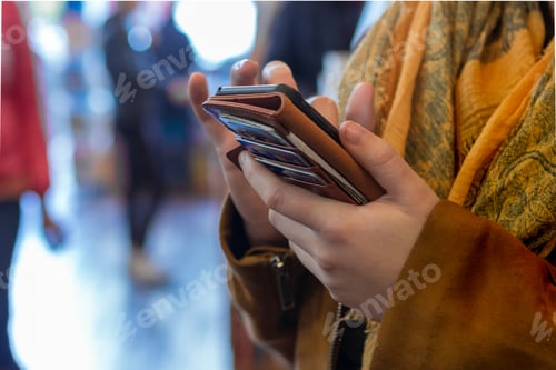 Preview: Woman’s hands in frame, online shopping with her mobile phone and wallet on the back, ready to pay