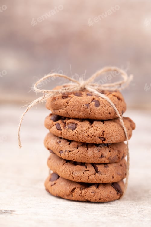 Preview: Image shows a stack of american chocolate chip cookies on rustic wooden plank.