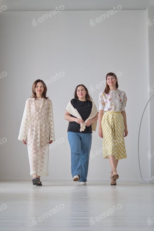 Preview: Three women walk confidently in a bright, minimalist space, each dressed in a unique style. The