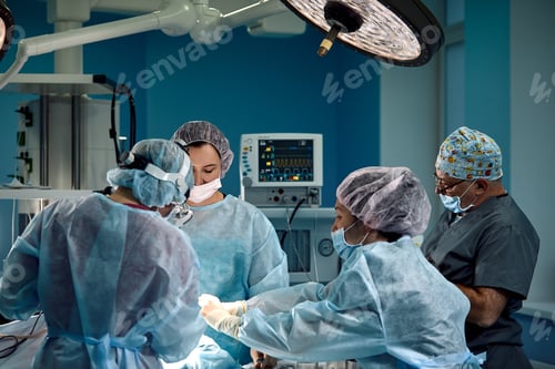 Preview: An international team of doctors during a real operation. saving lives, blue light.