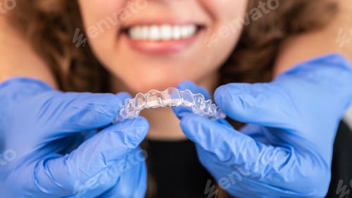 Preview: Orthodontist doctor putting silicone invisible transparent braces on woman teeth