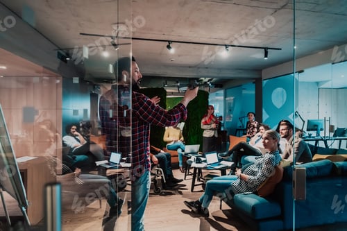 Preview: A bearded man in a modern office explaining to his young diverse team how a drone working
