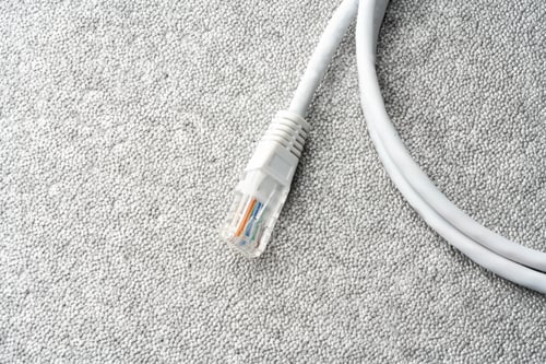 Preview: White network cable patch-cord on gray textured background