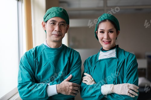 Preview: Asian male and female surgeon smiling to camera after finish surgery