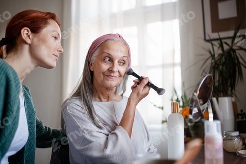 Preview: Senior woman making make up herself at home.