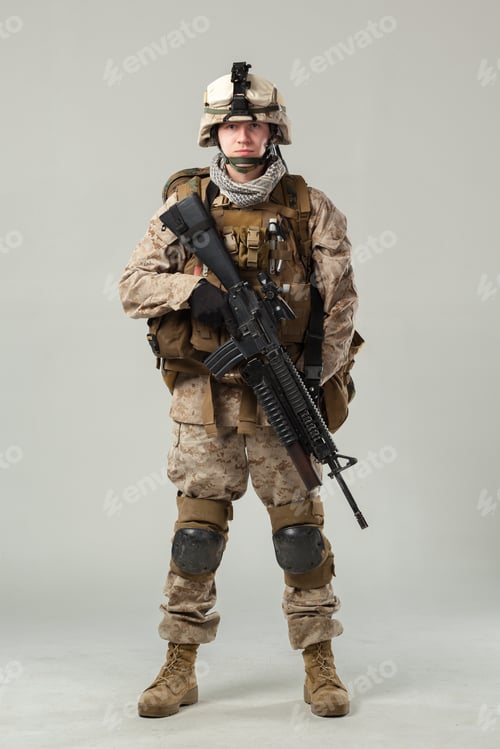 Preview: Soldier stands in uniform with rifle in a studio setting during a training session