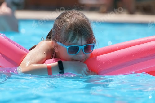 Preview: Young child girl relaxing on summer sun swimming on inflatable air mattress