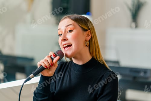 Preview: young girl sings in a vocal lesson with a microphone in her hands during a lesson at a music school