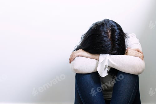 Preview: Woman looking depressed with the arms crossed and sitting on the floor