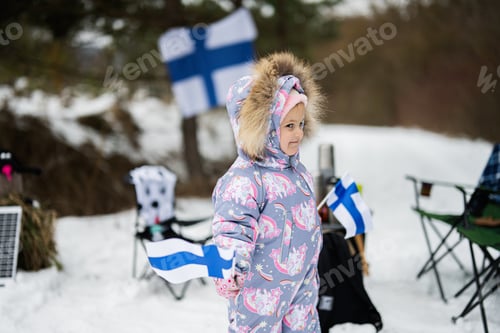 Preview: Finnish baby girl with Finland flags on a nice winter day. Nordic Scandinavian people.