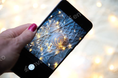 Preview: Hand holding phone and taking photo of christmas composition