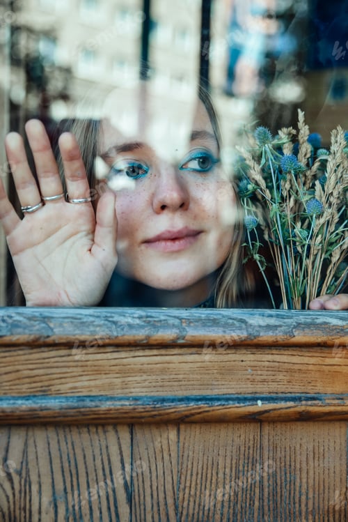 Preview: Young girl with big blue eyes outside the window.A touching waiting scene.