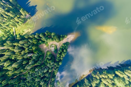Preview: Top down aerial view of big lake with clear blue water between high mountain hills