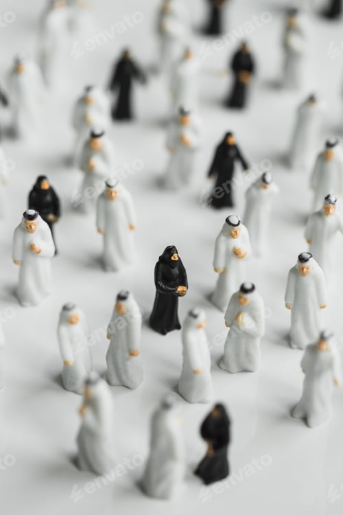 Preview: Selective focus shot of small statues of Muslim people with men in white robes and women in black