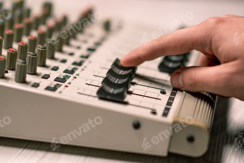 Preview: professional recording studio sound engineer with finger adjusts volume level mixing equalizer