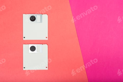 Preview: Classic floppy disks placed on pink and red background for retro technology display