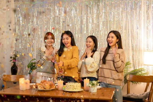 Preview: Young beautiful woman playing and pull poppers confetti party with enjoying while celebrating