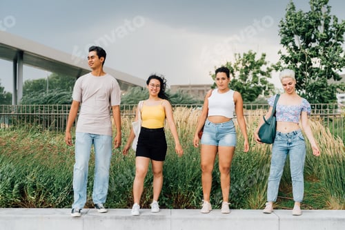 Preview: Group young muliethnic people friends walking outdoor posing on windy day smiling having fun