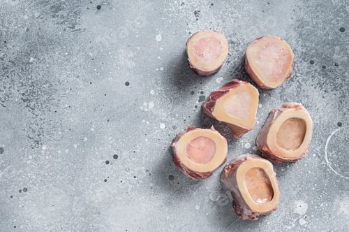 Preview: Raw calf Marrow bones on butcher table. Gray background. Top view. Copy space