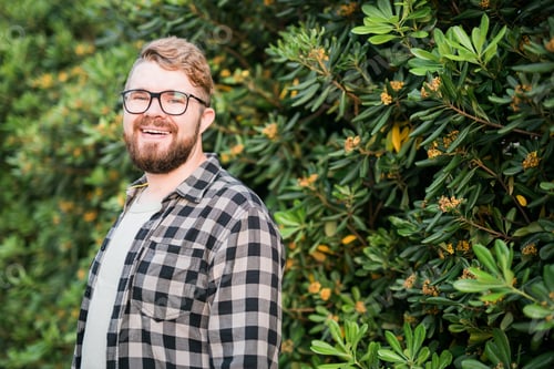 Preview: Close up portrait handsome young man over green bush outside copy space and place for advertising.