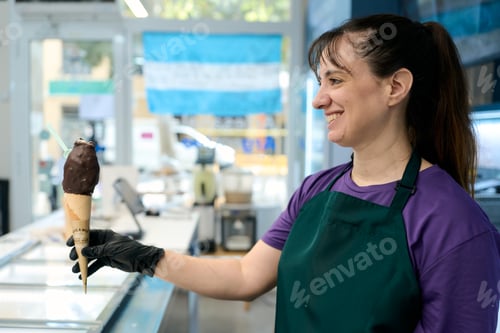 Preview: Ice cream shop worker showing delicious chocolate covered ice cream in argentina
