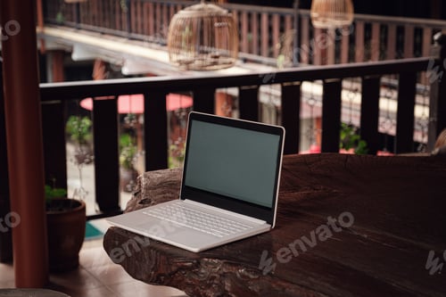 Preview: A white laptop on wooden table swiming pool background.