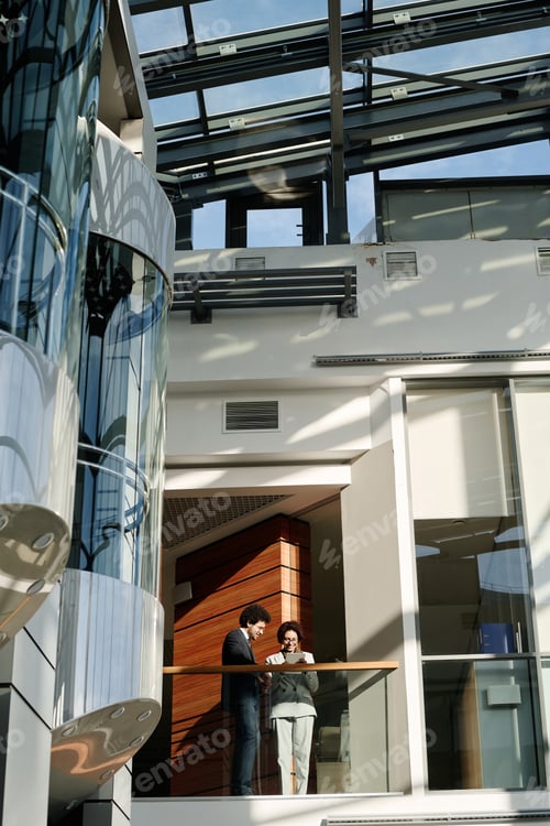 Preview: Business colleagues working in modern office centre