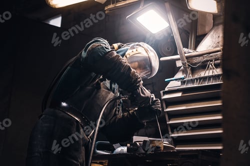 Preview: Diligent man is working with metal at workshop