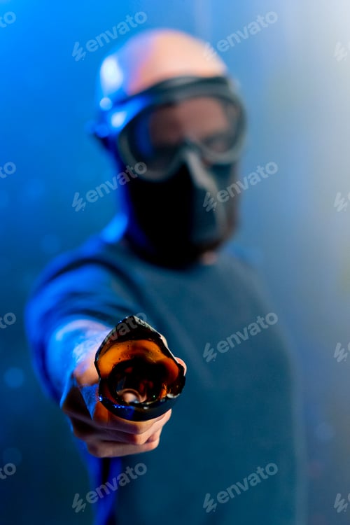 Preview: male robber in a mask holding a broken bottle in his hand threats attack robbery